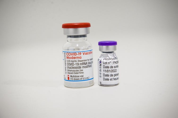 Fioles de Moderna et de Pfizer côte à côte
